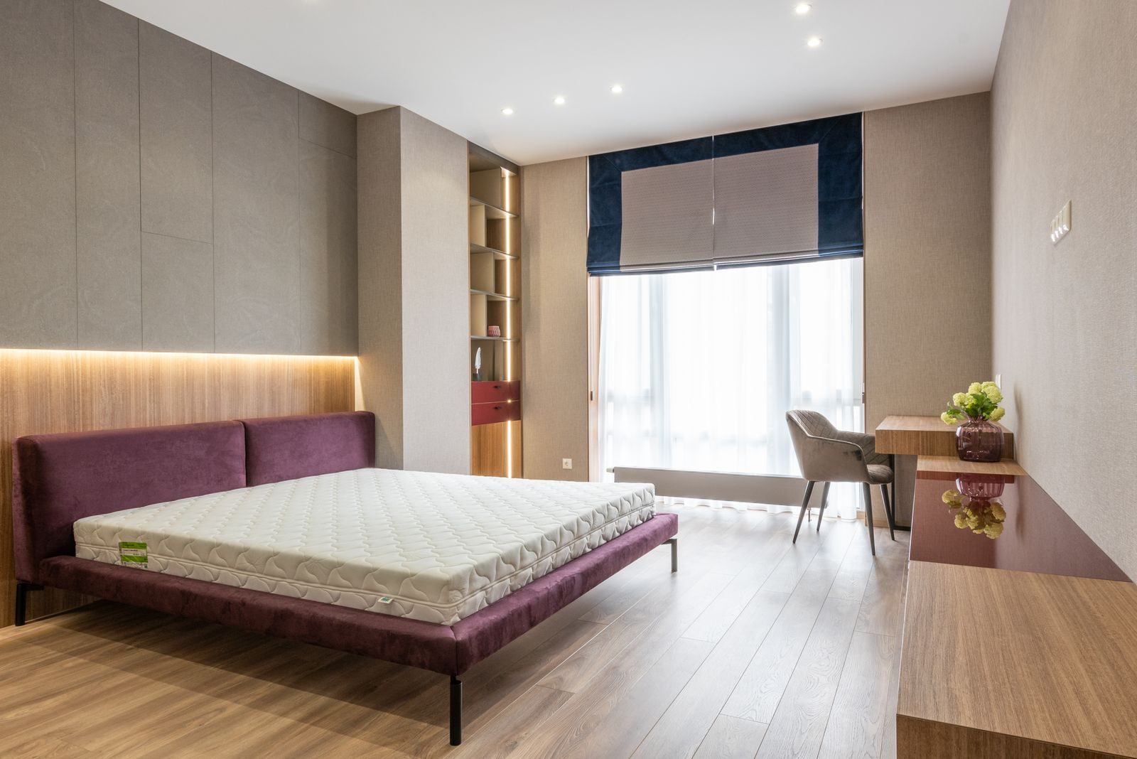 A bare mattress on a bed frame in a modern bedroom